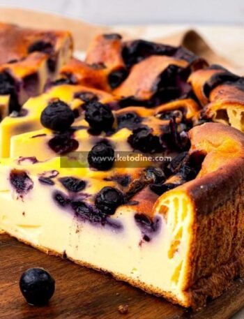 Preheat oven to 325°F (160°C). Line an 8-inch springform pan with parchment paper. Mix cream cheese and sweetener on medium speed until smooth and creamy (2–3 minutes). Add eggs one at a time, mixing on low speed until fully incorporated. Blend in protein powder and vanilla until smooth. The batter should be thick but pourable. Gently fold in blueberries using a spatula. Pour into prepared pan and smooth the top. Bake for 35–40 minutes until edges are set and center slightly jiggles. Cool at room temperature 30 minutes, then refrigerate at least 2 hours before slicing.